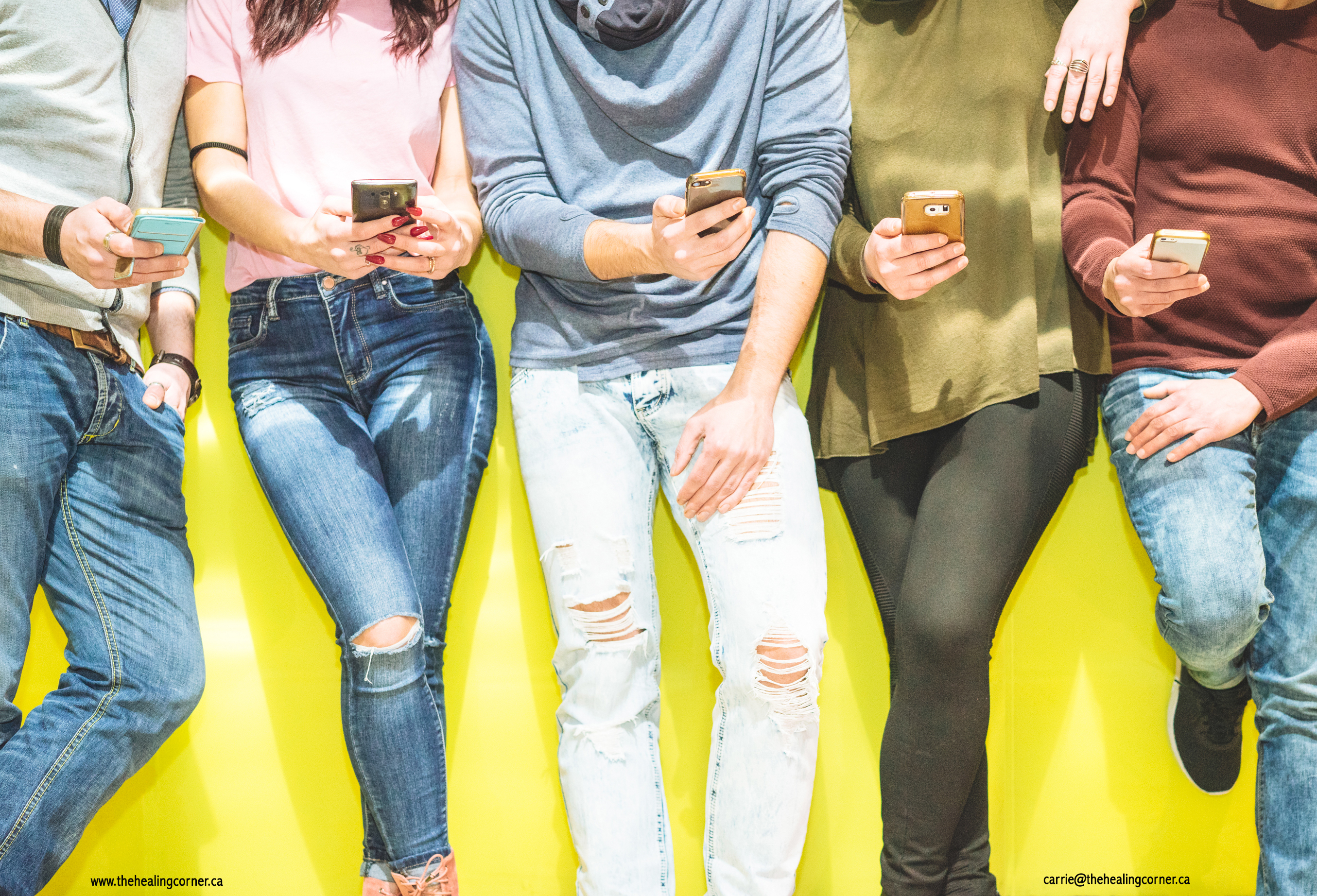 Group of friends having a social network moment watching on their mobile phones - People leaning on a yellow wall on their phones texting an